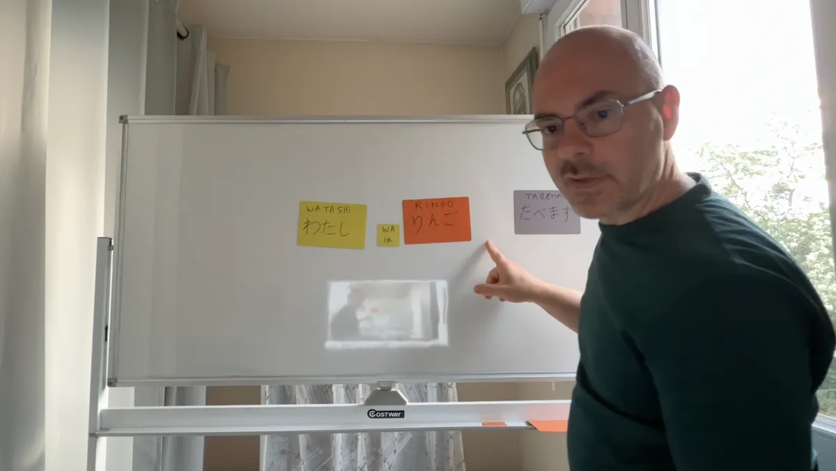 Le professeur au tableau blanc, construction d'une phrase japonaise avec les particules